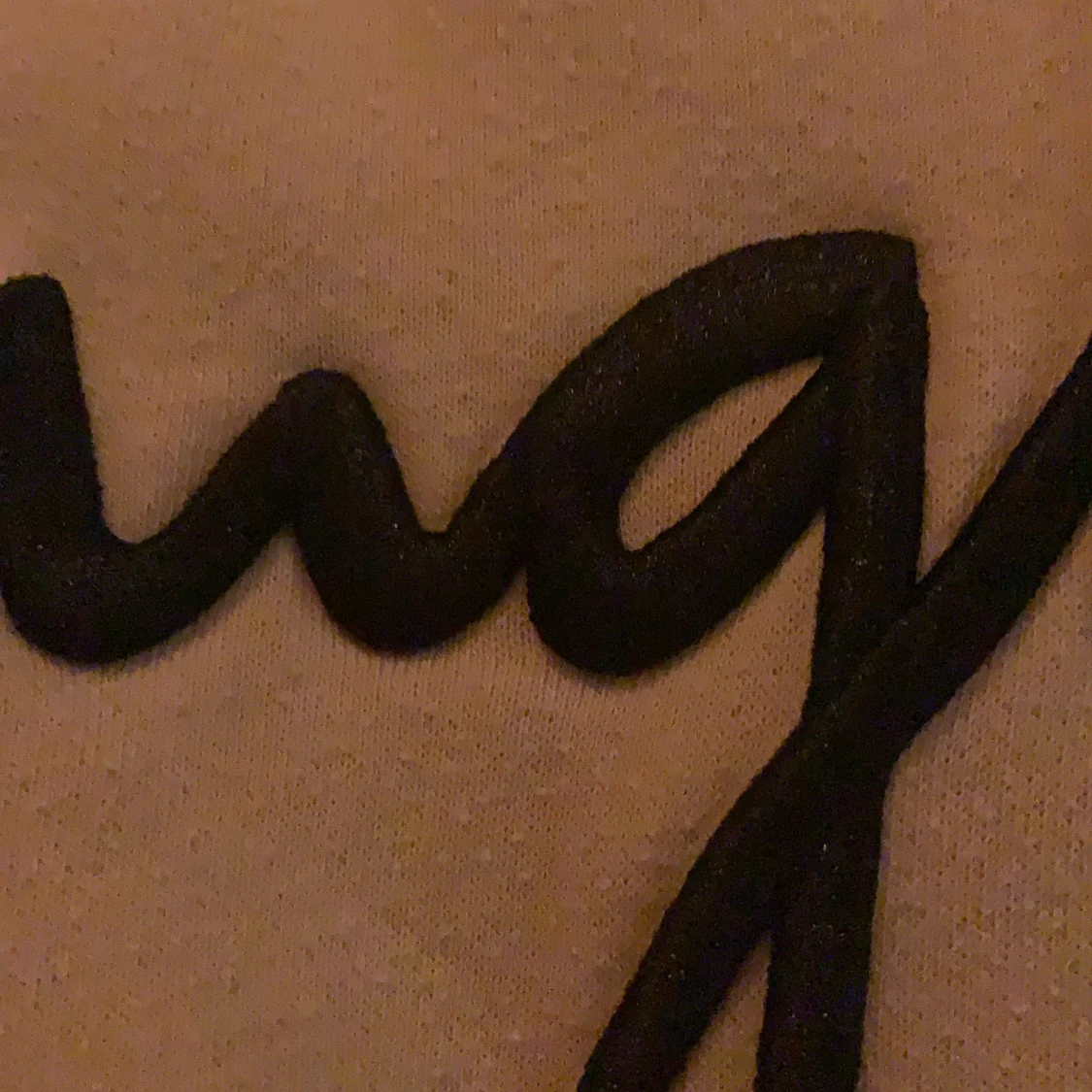 En beige Hoodie med svart text på - 91