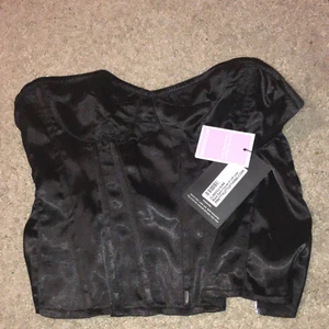 Svart Korsett - Svart korsett från prettylittlething, men köpt andrahand. 💓💓Endast provad. Storlek 6 UK size. Jag skulle säga att det motsvarar XS-XXS då jag kunde dra upp dragkedjan men det tog väldigt mycket och jag är en S-XS. Kolla vad storlek 6 motsvarar i mått på plt hemsida så ser ni också plaggets alla mått! Åker inte ner på bysten då den har någon gummistrand längst upp! skulle säga att den är rörlig att ha på sig ändå! Tveka inte med att kontakta mig och fråga om mer bilder!
