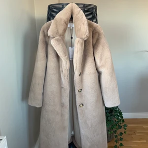 Dry lake x Vanessa Lindblad kappa stl xs  - Oanvänd kappa från dry lake som Vanessa Lindblad har designat. Inte riktig päls och är inte inuti bara på utsidan. Fint skick, aldrig använd, prislapp kvar. Band runt midjan ingår. 