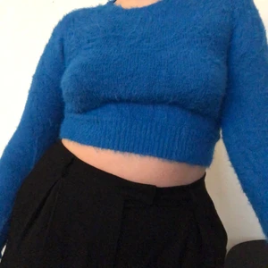 Fluffig tröja från Urban Outfitters - Fluffig blå tröja med ett litet igensytt hål (se bild 3), Storlek L, liten i storleken men strechig.