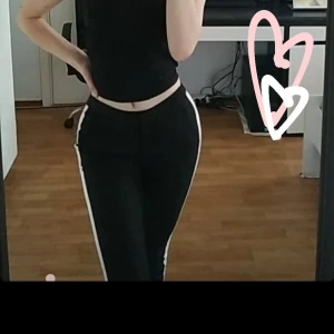 Tajta kostymbyxor med röd o vit rand på sidorna - Använda ett par gånger då de är små på mig. Storlek Xs. Köpta i New Yorker