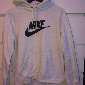 Nike hoodie - Fin vit/grå nike hoodie från junkyard. Har bara använt den fåtal gånger så den är i nyskick. (nypris 400kr.                                                                        Finns en liten fläck under nike märket men det ska jag nog få bort med lite vanish, annars inga fläckar eller lösa trådar. Storlek M passtar som en S. Tvättas innan leverans!😊🌸