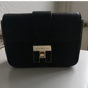 Äkta Tommy hilfiger väska - aldrig använts, har några år på nacken. Liten väska, får plats med mobil nycklar och något läppstift. Säljs pga flytt och att den använts ej