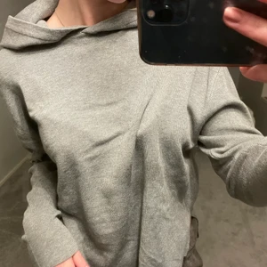 Finstickad hoodie - Grå finstickad Hoodie, andvänd en gång och i nyskick, två små slitts på vardera sida 
