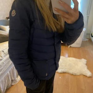 Moncler jacka  - Säljer min moncler jacka då den inte kommer till användning. Självklart äkta. Den passar Xs möjligtvis en liten S. Den är i ett använt skick men fortfarande användbar. Skriv till mig privat om du har frågor. Om flera är intresserade blir det budgivning. Det är en vårjacka så perfekt nu när vintern snart är över. Det kan finnas små defekter på jackan därav pris, finns ett litet hål.