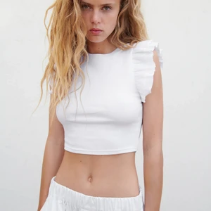 Volangtröja från zara - Jätte fin vit tröja från zara med volanger, tröjan är ribbad och i strl M men ganska liten i storleken. Så skönt material, säljer för 90kr+frakt! 