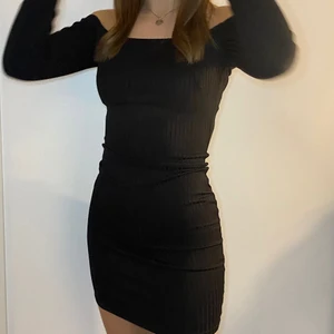 Svart klänning - Säljer denna tajta svarta klänningen från Nelly. Den är off shoulder och har som ett ribbat tyg. Den är nästan oanvänd och i superbra skick! Säljer för 160kr inklusive frakt men priset kan diskuteras.😊
