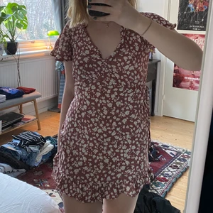 Rosa blommig klänning - Klänning från Pull & Bear. Köpt förra sommaren med råkade krympa i längden i tvätten :( jag är 162 och skulle säga att den passar någon som är något kortare. 🌞