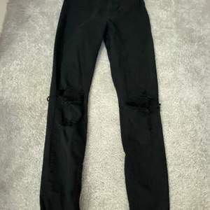 Ett par svarta jeans med håll på båda knäna. Säljer dom för att jag aldrig använt dom