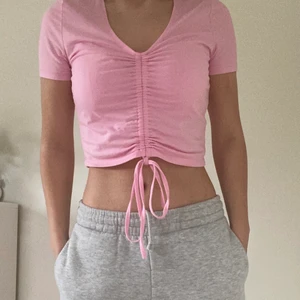 Rosa t-shirt strl S - En rosa tröja med band så man kan välja hur långt ner den ska gå, strl S, använda några gånger