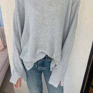 Trendig stickad tröja - Ljusblå stickad tröja med pärldetaljer på ärmarna, har några små defekter. Är i storlek L men passar mig bra som är XS/S då den blir snyggt oversized🥰