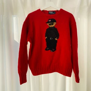 Stickad polo-tröja med björn motiv - Svårhittad stickad begagnad björntröja från Ralph Lauren.   Lappen säger XL men tror den krympt i tvätt så inte verklig storlek. Bred men kort. Unisex.   Men strl: S/M Woman strl: M/L 