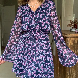 Söt sommarklänning med band - Helt oanvänd blommig sommarklänning. Storlek 36 med resår i midjan samt tillhörande band. Frakt tillkommer utöver priset <3