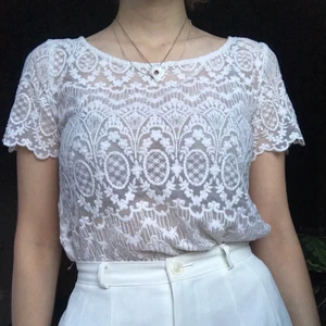 Spetstopp i mesh - En vit mesh-topp med ett broderat spetsmönster✨ Ej sticksig och bra skick! Elegant topp som kan kombineras vilt. Frakten inräktnat i priset! 