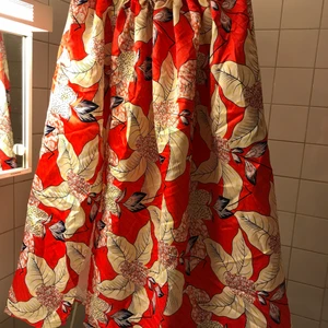 Stor röd kjol - En lång kjol med mkt typ stora blommor som mönster, en lång slits i sidan och en markant resår i midjan!