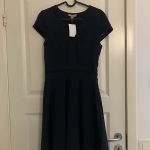 En marinblå klänning från H&M, oanvänd med prislapp kvar. Fina detaljer