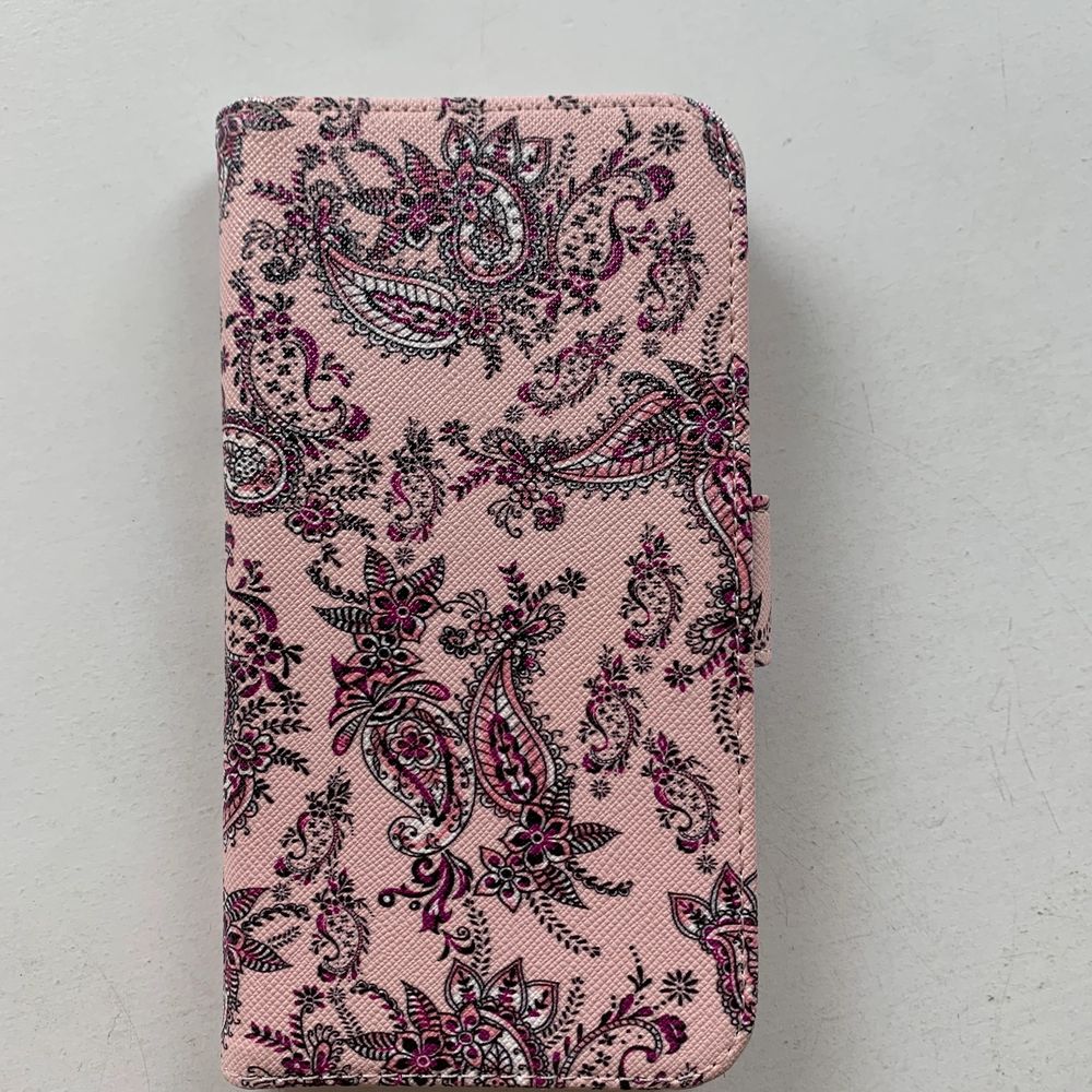 Rosa magnetiskt plånboksskal till mobilen med mönster på. Finns plats för tre kort + ett stort fack under. Kommer ifrån holdit och passar iPhone XR. Fint skick, nästan aldrig använt. Skalet kostar 100 kr, frakt ingår ej. Swipe för fler bilder.. Övrigt.