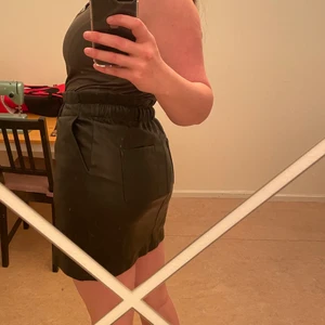 Svart läderkjol - Skitcool och stretchig (fake) svart läderkjol med bakfickor. Superskön med stretchig midja. Aldrig använd, lappen sitter kvar (har tappat bort kvittot). 