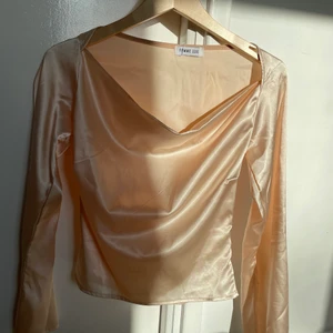 Satin topp / blus  - Satin topp / blus i storlek XS från märket Femme Luxe. I en jättefin creme färg.