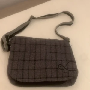 väska - säljer min gråa axelarmsväska med en liten sköldpadda på passar exakt storleken på en macbook🐢👩‍💻 funkar funder för skolan B)