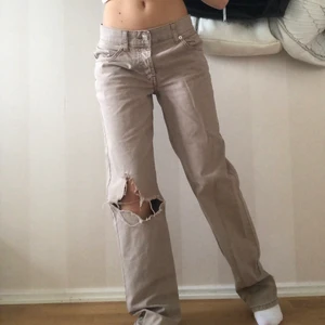Lågmidjade jeans - Ett par beigea lågmidjade jeans med hål, sitter så najs och är verkligen så coola. 