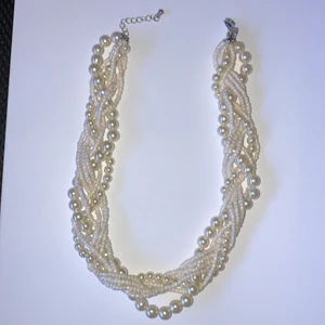 Vitt pärl halsband - Ett vitt pärl halsband med dekorationer.