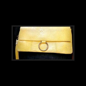 Skinnclutch - Skinnväska , clutch från Decadent. Ny. Storlek 24*13 cm. Knäpps med tryckknapp. Guldspänne. Klar kall gul färg. 