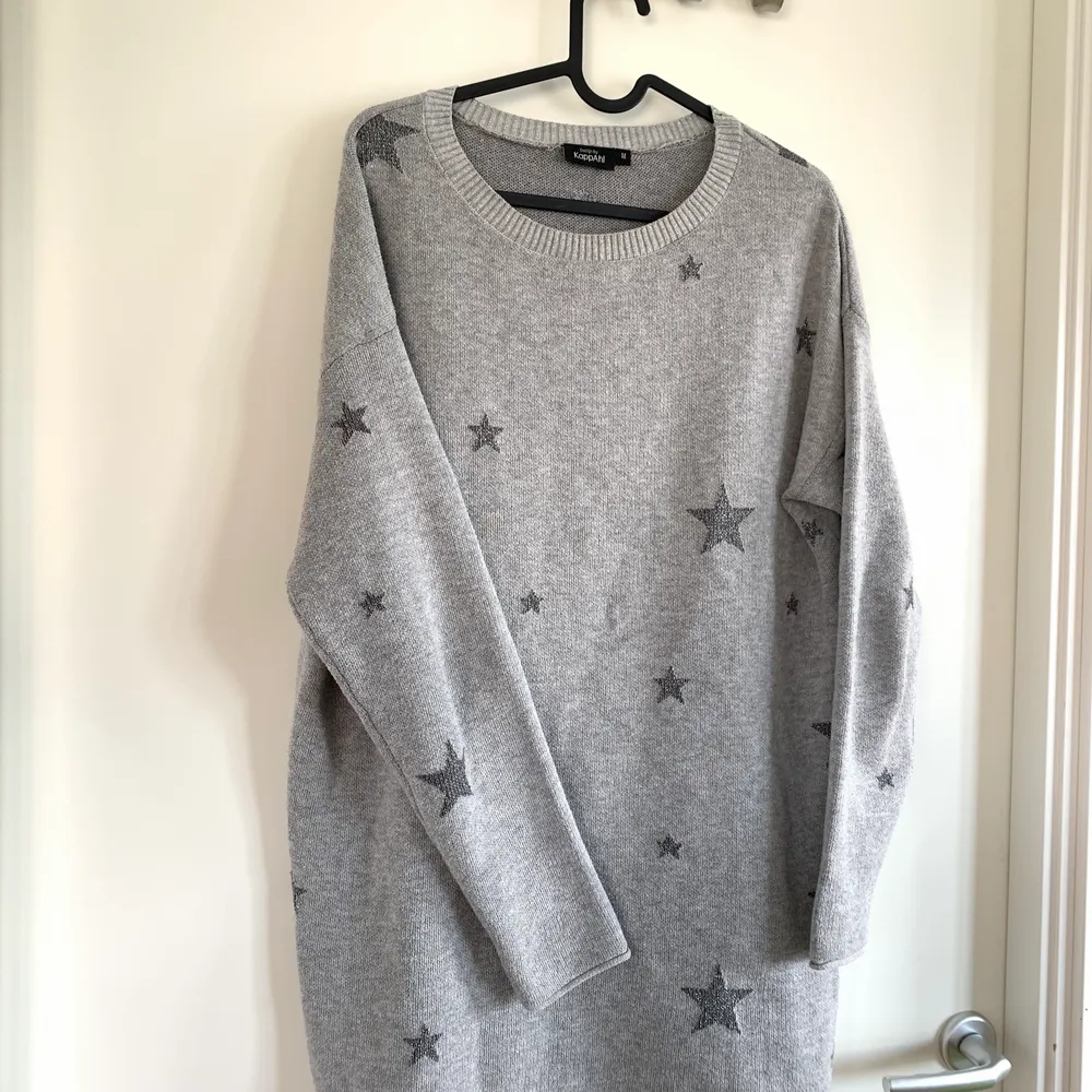 En helt oanvänd grå stickad tröja med glittriga stjärnor. Köpt på Kappahl, storlek M. Ganska lång modell men inte lång nog att använda som klänning (för mig som är 175cm). Tunnare i materialet. Tröjor & Koftor.