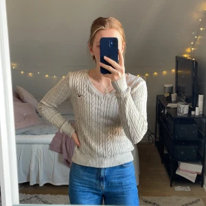 Beige Kabelstickad tröja - Knappt använd kabelstickad tröja från Hollister. Lite större i storleken, långa armar och något kortare. V ringning