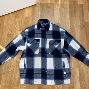 Rutig jacka -ZARA - Säljer denna fina jacka från Zara. Mörkblå/ Vit. Den är i storlek XS, men den är oversize i storleken. Bud från 300kr då den är i väldigt bra skick. Ordinare pris ca 800kr. Jag står inte för fraktkostnaden.