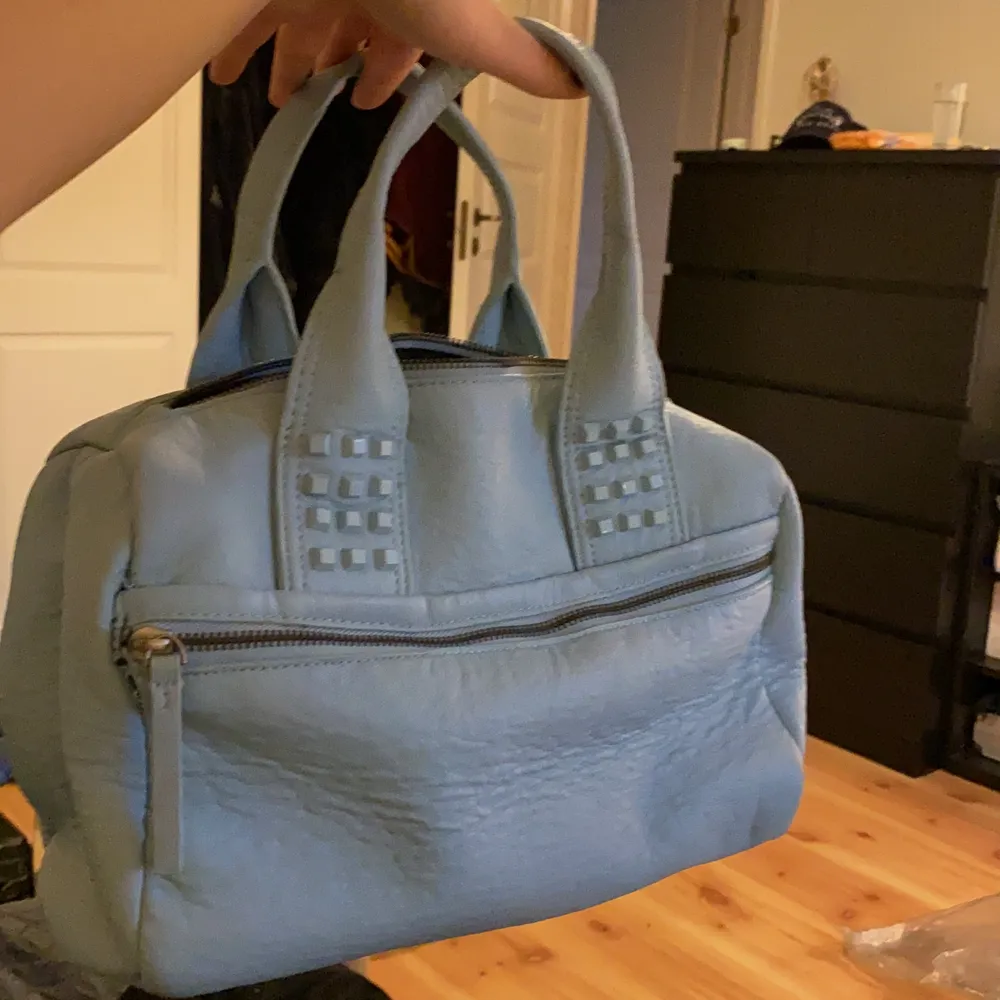 Ljusblå jättefin handväska med nitar och fickor framtill samt inuti. Använd max 2ggr. . Väskor.