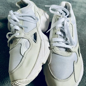 adidas Originals FALCON W. - Falcon hämtar inspiration från löpardesigner från 90-talet och den sorglösa, upproriska andan hos det årtiondets konst, musik och mode. Dessa skor har en tydlig 90-talslook med livliga färger samt en bred och kraftig siluett. De har en ovandel i mesh och en tjock mellansula som ger komfort hela dagen.