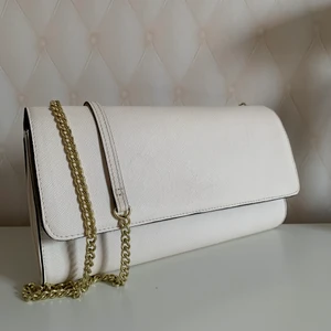 Kuvertväska - Vit/beige kuvertväska med axelband med guldiga detaljer, inga synliga slitagetecken🤍🦢