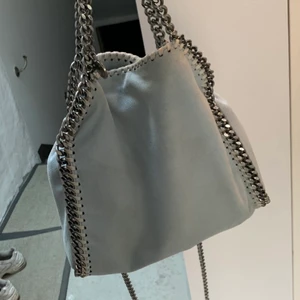 Stella Mccartney väska - Säljer min ljusblåa stella väska 💕 den är ca 2 år gammal, i fint skick utom en defekt ( se sista bilden ) som enkelt går att laga hos en skräddare för en billig peng skulle jag tro ⭐️  äkthetsbevis och dustbag tillkommer💛 