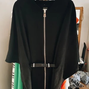 Cape från River island  - Cape i fint skick från River island. På sidorna finns det hål ifall du vill ha ett bälte till. OBS bältet kommer inte med utan är bara för att visa hur det kan se ut! 