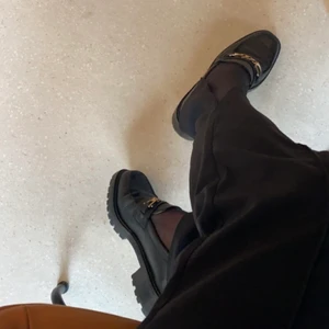 Loafers & Other Stories - Svarta loafers med guld detalj framtill från & other stories i fint skick (endast använda ett par gånger). Fungerar perfekt alla årstider. 