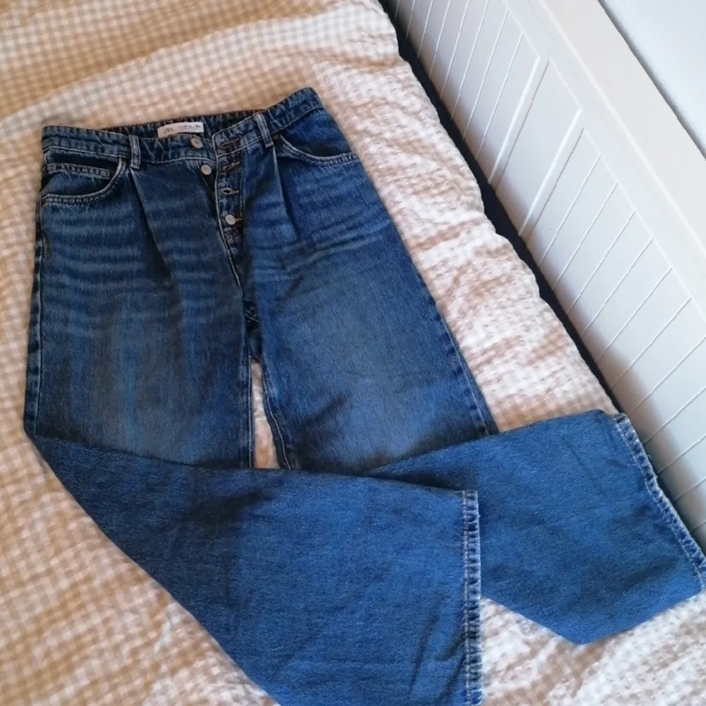 Jeans wide leg med slitningar. Köpte dem 2019,   använda cirka ett halvt år. Jag är ungefär 160 cm och dem slutar ungefär i mitten av mina vader. . Jeans & Byxor.
