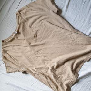 En beige t-shirt ifrån H&M som jag anvönt 1 gång. Den säljs i storlek M. Tyget är vädligt lätt och sladdrigt. Säljer denna för 20kr och jag står för frakten 😊