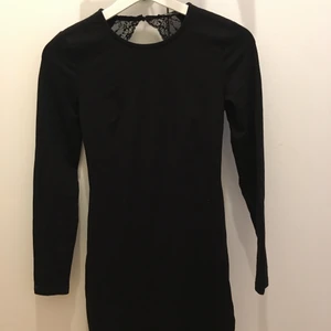 Gina klänning  - Svart klänning med öppen ryggo och spetts detaljer 