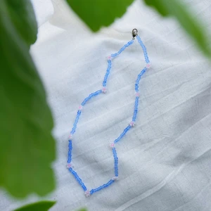 Pärlhalsband ”Lilja” - LILJA är ett pärlhalsband som är ca 40cm långt. Den har en karbinhake som håller ihop smycket.