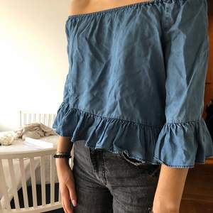 Denim färgad offshoulder blus med volang detaljer. Original pris 400kr