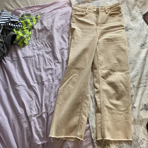 Beiga jeans - Beiga jeans som har fått ett litet hål på grund av att jag drog i dem. Typ High waist 