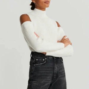 Stickadtröja - Stickad tröja med cutout detaljer på axlarna. Tröjan är vit, stickad och långärmad. Den har en låg polokrage. Jätte mysig tröja. Helt ny och aldrig använd! Stl XS