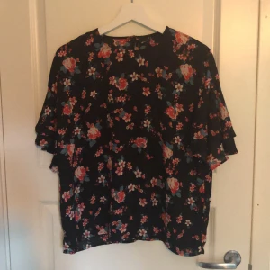 Blus  - T-shirt modell med välsydd ärm! Knapp i nacken och volangärm! 