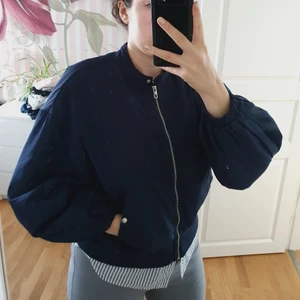 Marinblå bomberjacka från zara - Säljer en marinblå bomberjacka med puffärmar. Det ser ut som att man har en skjorta under vilket jag tycker är en cool detalj. Köparen står för frakt.