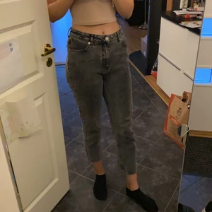 Svart/grå jeans stl 40 - Ett par svart/gråa jeans från NA-KD i storlek 40 säljes. De är mid rise med raka ben. De är oanvända och det är självklart inget fel på dem, har tyvärr för långa ben för att de ska passa bra. 