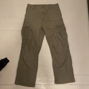 Carhartt byxor - Använt skick med ett hål vid ena fickan och små slitninga. 