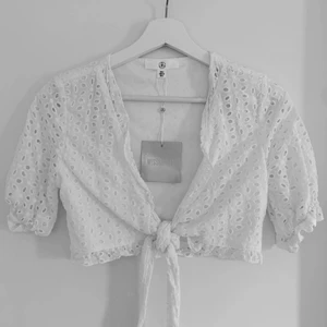 Vit croptop med knyte i midjan  - Vit oanvänd croptop från Missguided. Passar till alla tillfällen. Lappen är fortfarande kvar. Pris kan diskuteras. 