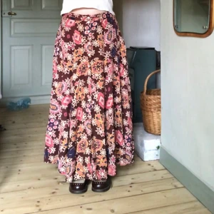 mönstrad långkjol - Riktigt härlig mönstrad långkjol! Vintage, väldigt bra skick bortsett från att två knappar saknas, en längst ned och en på mitten. Fint rosa, brunt mönster och knappar på framsidan. 100% viscose. Går ner till marken på mig som är 160. Midjemått: 78cm. Längd: 86cm. Kolla gärna in mina andra annonser, samfraktar! 💙