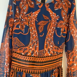 Långklänning - Indisk/orientalmönstrad långklänning. Figursydd överdel. Likadan klänning som Carola har. Klänningen är lång ocy går ner till fötterna på den som är 170 cm lång. 